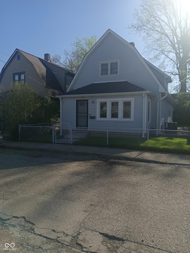 dutch colonial featuring a gambrel roof and a fenced front yard