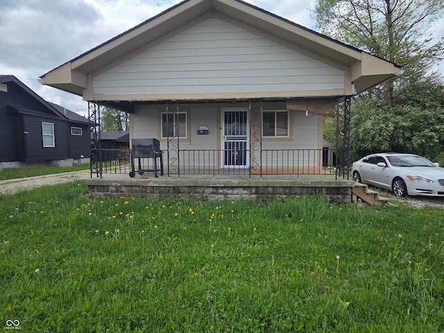 bungalow-style house with covered porch and a front yard