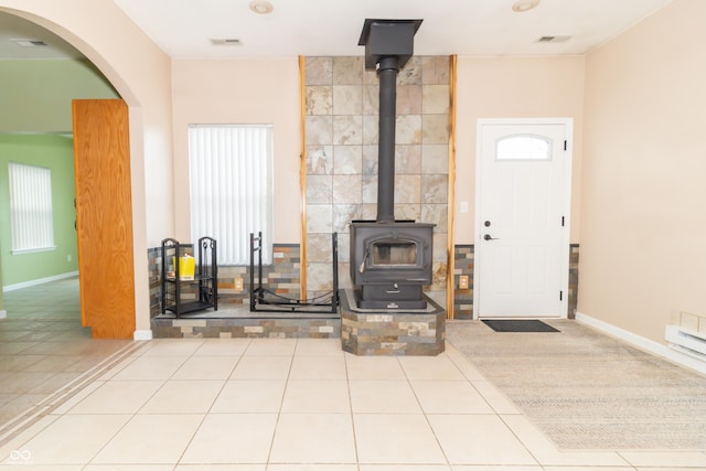 2761 Winding Creek Ln, Greenfield, IN 46140 - living room featuring a wood stove, tile patterned flooring, and arched walkways