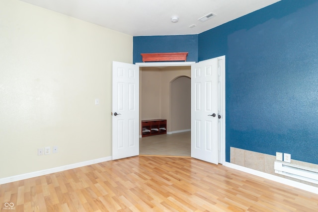 2761 Winding Creek Ln, Greenfield, IN 46140 - spare room featuring arched walkways, light wood-style floors, and a smoke detector