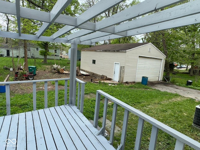 deck featuring a detached garage, concrete driveway, an outbuilding, a pergola, and a lawn
