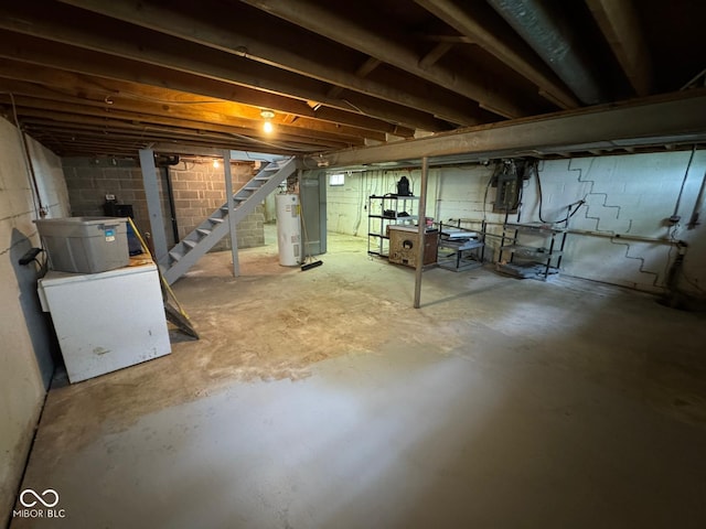 unfinished below grade area featuring electric water heater and stairs