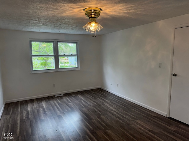 spare room with dark wood finished floors, baseboards, a ceiling fan, and a textured ceiling