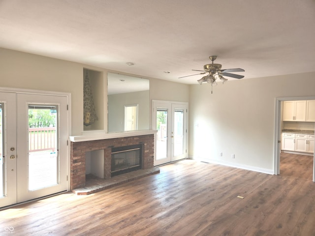 9909 E Mcgregor Rd, Indianapolis, IN 46259 - unfurnished living room with healthy amount of natural light, wood finished floors, ceiling fan, and a brick fireplace
