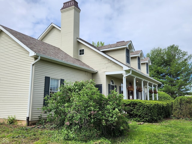 9909 E Mcgregor Rd, Indianapolis, IN 46259 - view of property exterior with roof with shingles, a porch, and a chimney