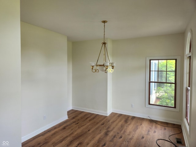 9909 E Mcgregor Rd, Indianapolis, IN 46259 - unfurnished dining area with a chandelier, dark wood-type flooring, and baseboards