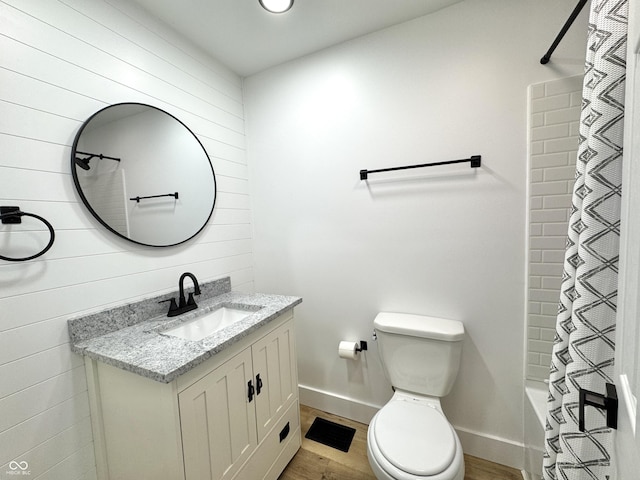 full bathroom featuring vanity, toilet, baseboards, and wood finished floors