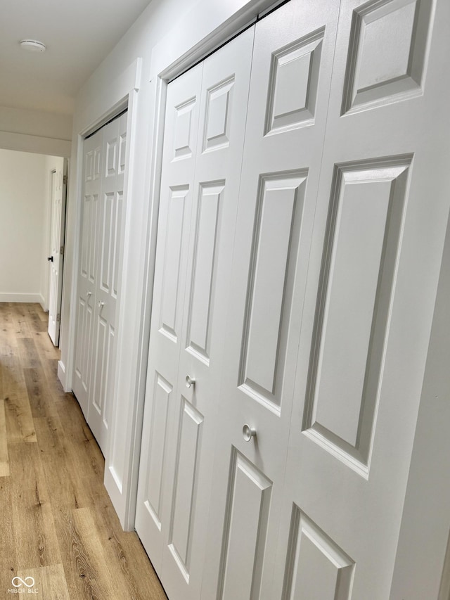 hall with light wood finished floors and baseboards