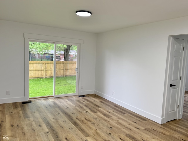 empty room with visible vents, wood finished floors, and baseboards