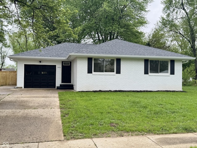 ranch-style house with a front lawn, roof with shingles, brick siding, concrete driveway, and an attached garage