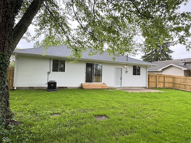 back of property with cooling unit, a yard, fence, and entry steps