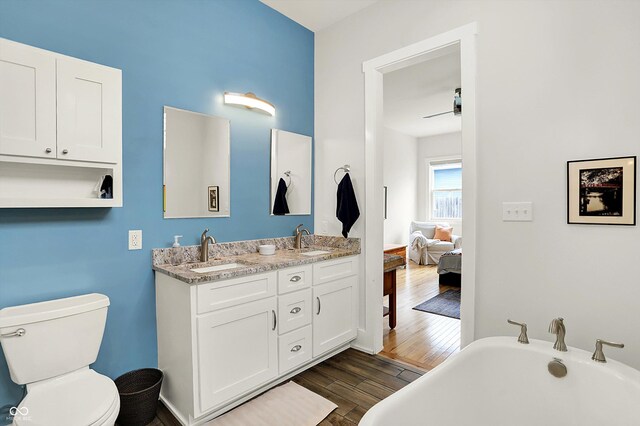 829 Olive St, Indianapolis, IN 46203 - ensuite bathroom with a freestanding tub, wood finished floors, toilet, and double vanity