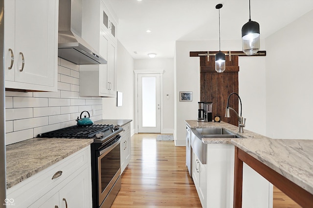 829 Olive St, Indianapolis, IN 46203 - kitchen with stainless steel range with gas cooktop, wall chimney exhaust hood, light wood-style flooring, backsplash, and recessed lighting