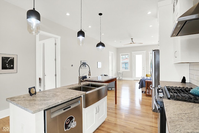 829 Olive St, Indianapolis, IN 46203 - kitchen featuring appliances with stainless steel finishes, under cabinet range hood, light wood finished floors, a kitchen island with sink, and recessed lighting