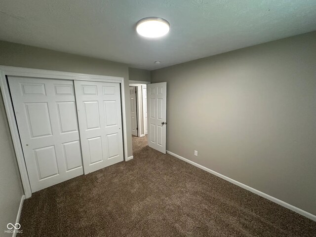 2453 Larnie Ln, Indianapolis, IN 46219 - unfurnished bedroom featuring dark carpet and a closet