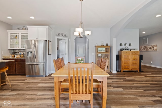 dining space with arched walkways, recessed lighting, baseboards, light wood-type flooring, and visible vents