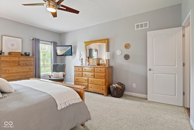 bedroom featuring baseboards, light carpet, a ceiling fan, and visible vents