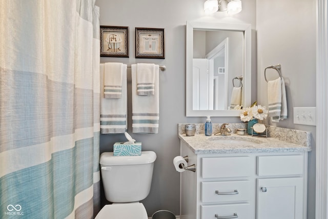 bathroom with vanity, a shower with shower curtain, and toilet