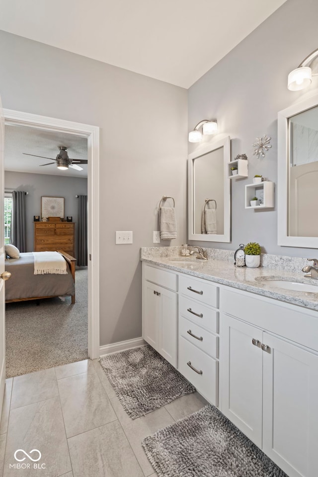 bathroom with double vanity, a sink, ceiling fan, and ensuite bath