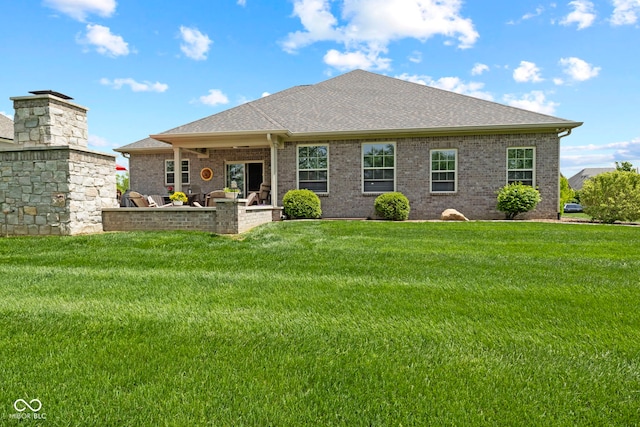 rear view of house featuring a lawn, roof with shingles, and brick siding