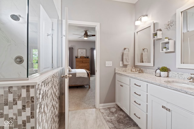 ensuite bathroom featuring connected bathroom, ceiling fan, walk in shower, a sink, and double vanity