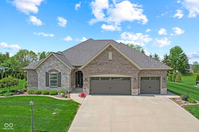 view of front of property featuring an attached garage, roof with shingles, driveway, and a front yard