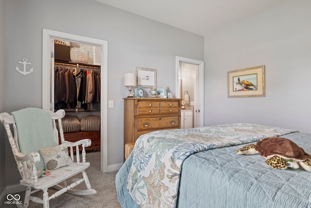 carpeted bedroom featuring baseboards, a walk in closet, and a closet