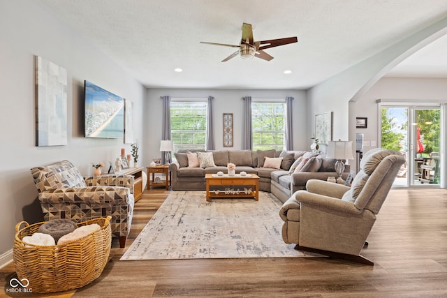 living area featuring arched walkways, a ceiling fan, recessed lighting, and wood finished floors