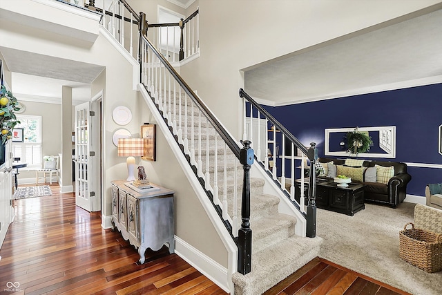 stairs featuring hardwood / wood-style floors, ornamental molding, and baseboards