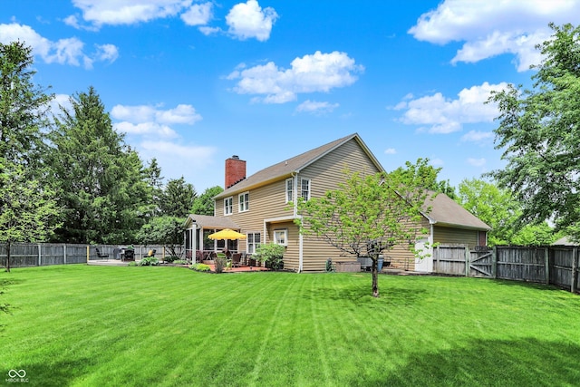 back of property featuring a chimney, a gazebo, and a gate