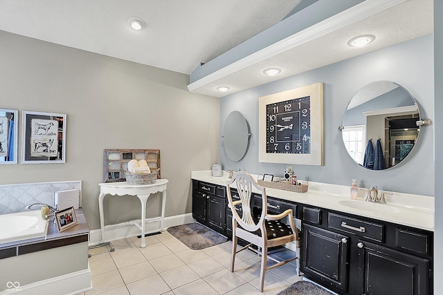 bathroom with tile patterned floors, vanity, a garden tub, and baseboards