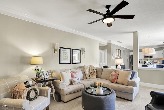 living area with crown molding, light carpet, a ceiling fan, and baseboards