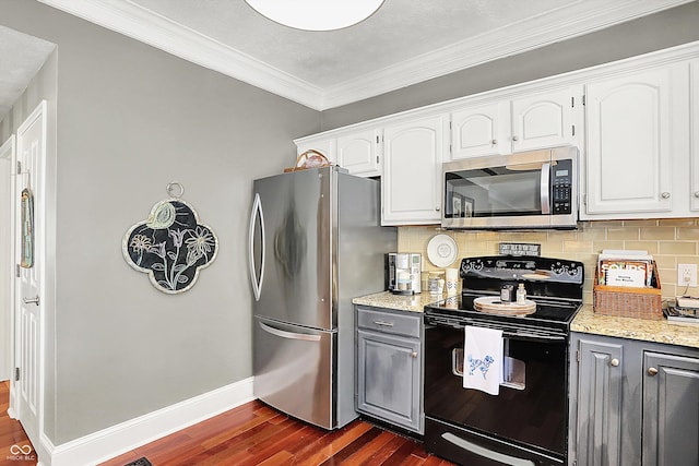 kitchen with stainless steel appliances, dark wood-style floors, decorative backsplash, white cabinets, and baseboards