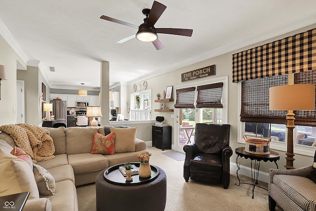 living room with ornamental molding, a ceiling fan, light colored carpet, and baseboards