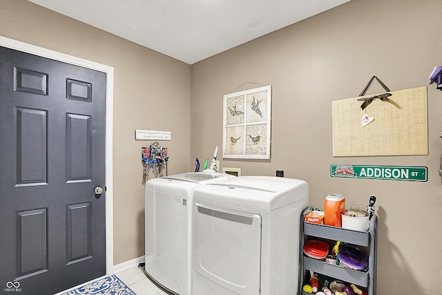 washroom with independent washer and dryer, light tile patterned floors, and baseboards