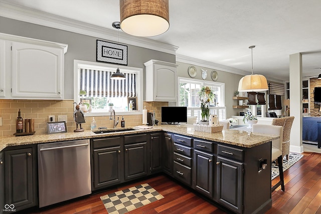 kitchen with stainless steel dishwasher, a sink, white cabinetry, a peninsula, and tasteful backsplash