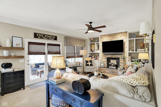 living area featuring a ceiling fan, light carpet, built in shelves, and a fireplace