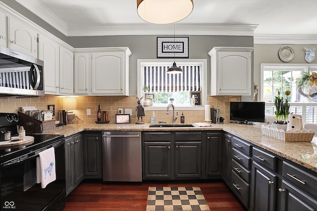 kitchen with a sink, stainless steel appliances, white cabinetry, healthy amount of natural light, and crown molding