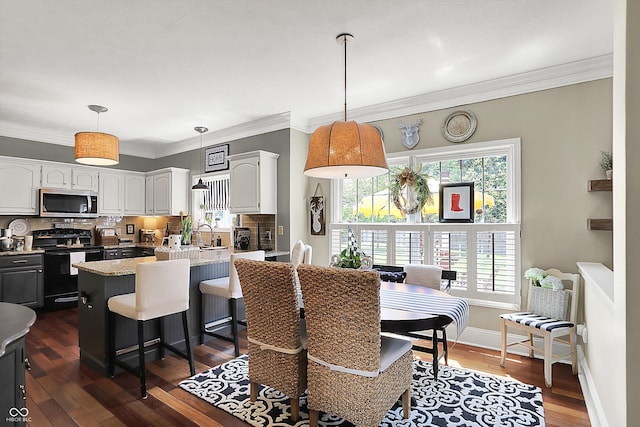 dining area featuring dark wood finished floors, crown molding, and baseboards