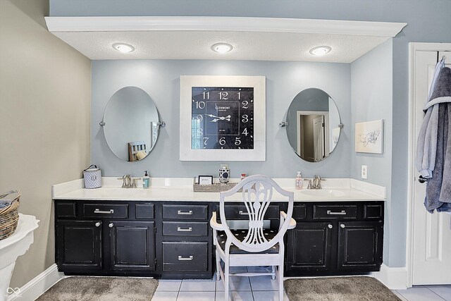 bathroom featuring vanity, tile patterned flooring, baseboards, and a textured ceiling