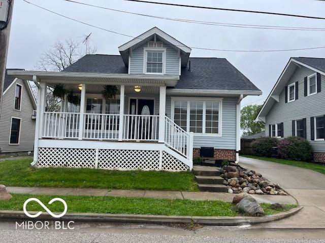 view of front facade featuring covered porch and roof with shingles