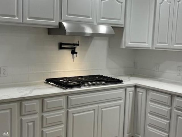 223 E Fordice St, Lebanon, IN 46052 - kitchen with white cabinets, light stone countertops, backsplash, wall chimney range hood, and stainless steel gas cooktop