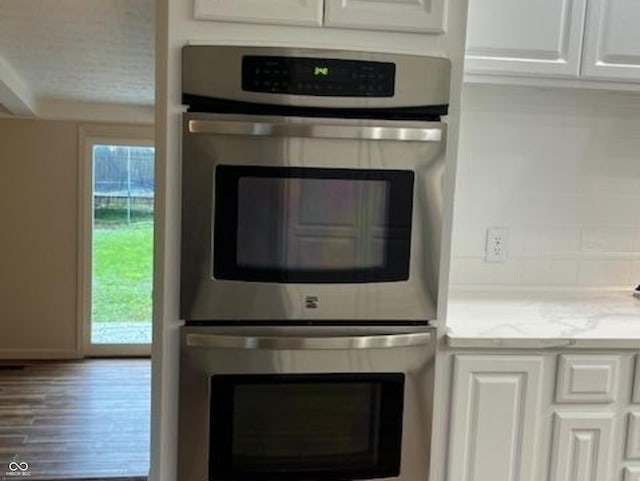 223 E Fordice St, Lebanon, IN 46052 - interior details with white cabinets, double oven, wood finished floors, and light stone countertops