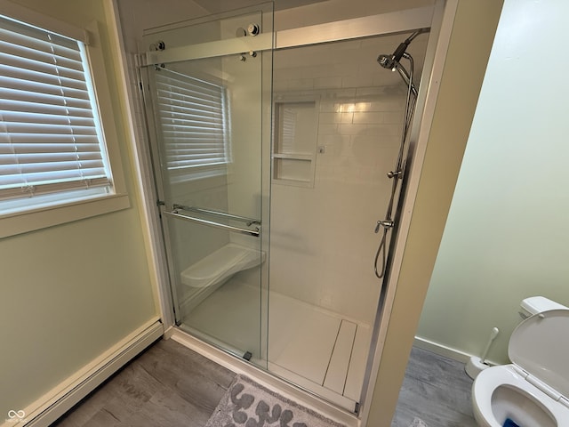 7140 N Michigan Rd, Fairland, IN 46126 - bathroom featuring a baseboard heating unit, baseboards, a stall shower, wood finished floors, and toilet