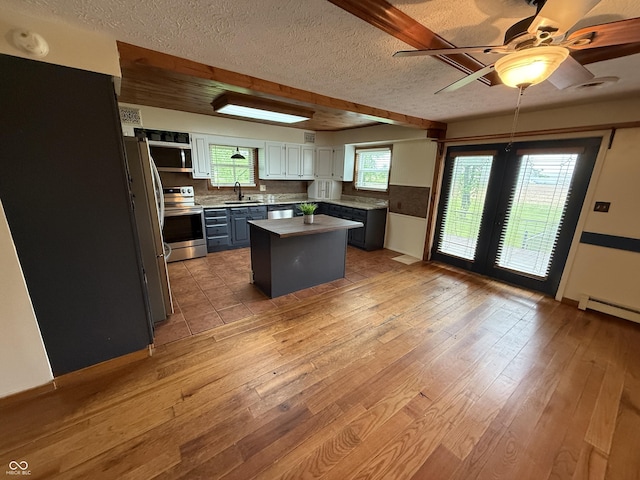 7140 N Michigan Rd, Fairland, IN 46126 - kitchen with a sink, stainless steel range with electric cooktop, a textured ceiling, freestanding refrigerator, and light wood-style floors