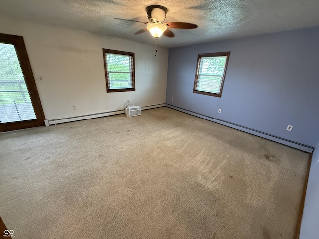 7140 N Michigan Rd, Fairland, IN 46126 - spare room featuring a baseboard radiator, a textured ceiling, healthy amount of natural light, a ceiling fan, and light colored carpet
