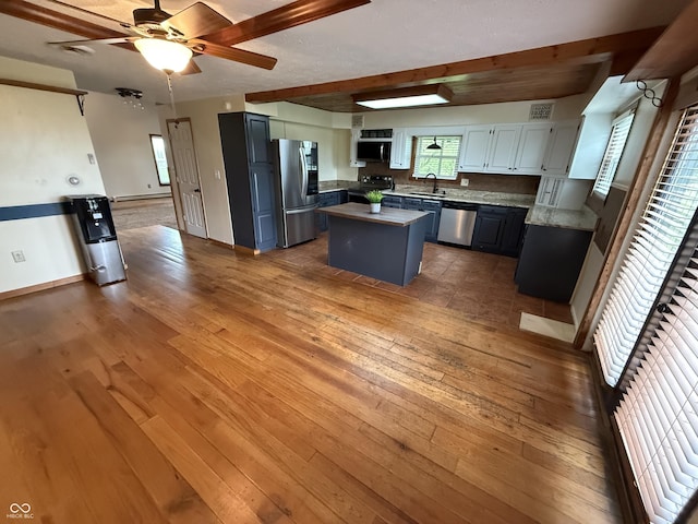 7140 N Michigan Rd, Fairland, IN 46126 - kitchen featuring appliances with stainless steel finishes, a sink, a kitchen island, a ceiling fan, and wood-type flooring