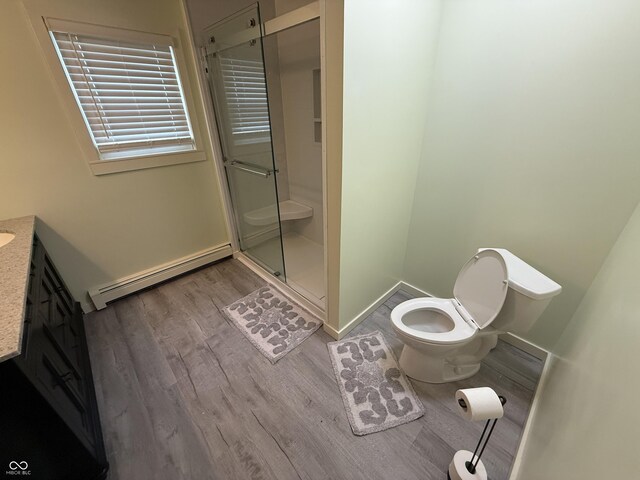 7140 N Michigan Rd, Fairland, IN 46126 - full bathroom featuring a baseboard radiator, wood finished floors, a stall shower, vanity, and toilet