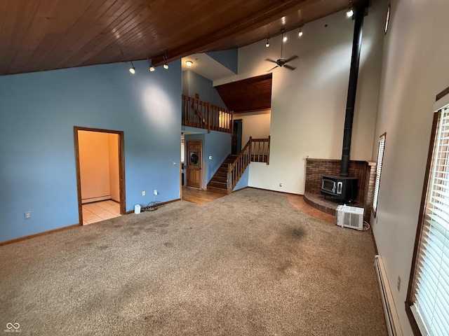 7140 N Michigan Rd, Fairland, IN 46126 - unfurnished living room featuring track lighting, high vaulted ceiling, carpet flooring, a wood stove, and a baseboard heating unit