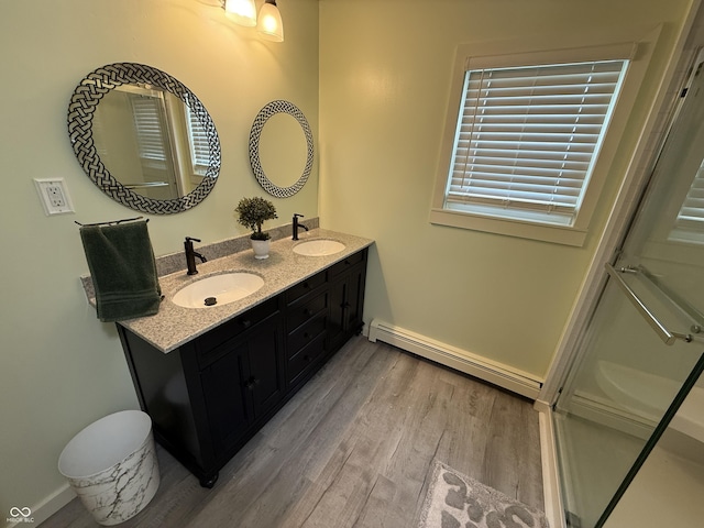 7140 N Michigan Rd, Fairland, IN 46126 - bathroom with baseboard heating, wood finished floors, double vanity, a shower stall, and baseboards